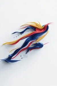 Abstract speed logo with layered blue, red, yellow, and white paint strokes creating a motion-inspired running shape. AI-generated